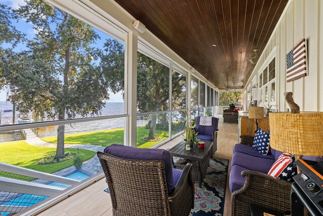 sunroom with a water view and wood ceiling