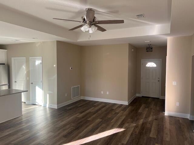 foyer entrance featuring dark hardwood / wood-style floors, a raised ceiling, and ceiling fan