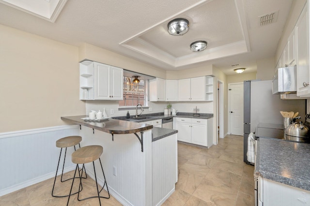 1905 W Mistral Ln, Fort Walton Beach, FL 32547 - kitchen featuring open shelves, a peninsula, white microwave, dark countertops, and a wainscoted wall