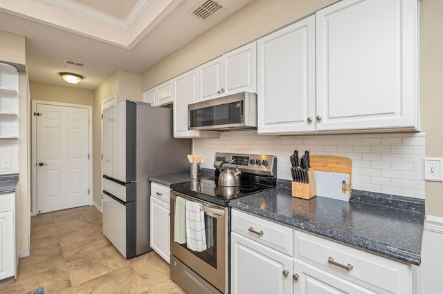 1905 W Mistral Ln, Fort Walton Beach, FL 32547 - kitchen featuring appliances with stainless steel finishes, white cabinets, tasteful backsplash, crown molding, and dark stone counters