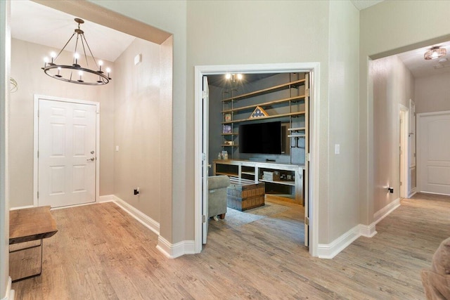 corridor with an inviting chandelier and hardwood / wood-style flooring