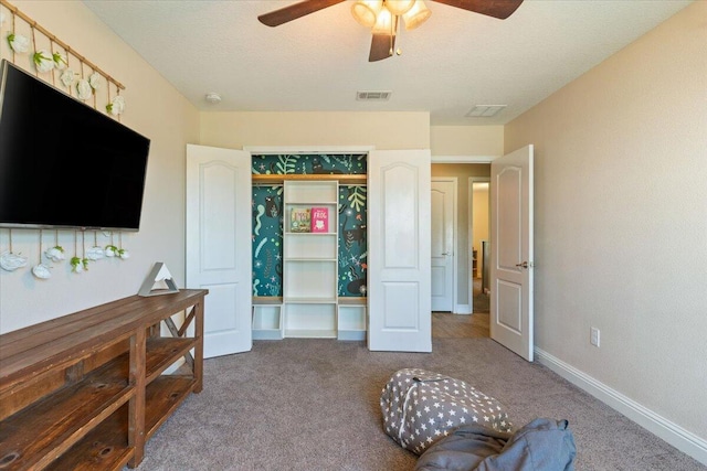 bedroom with a textured ceiling, carpet floors, and ceiling fan