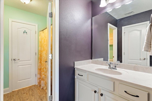 bathroom with hardwood / wood-style flooring, vanity, a textured ceiling, and a shower with shower curtain