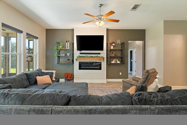 living room featuring ceiling fan, wood-type flooring, and a textured ceiling