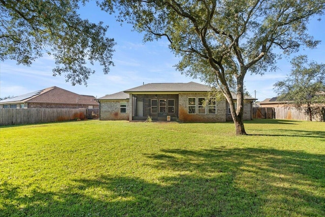 rear view of property with a yard