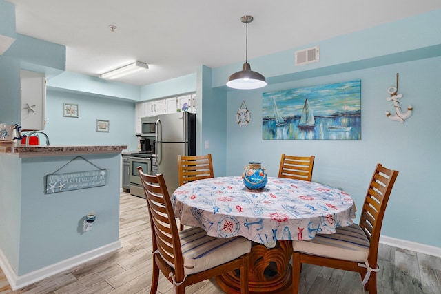 dining space with light hardwood / wood-style flooring