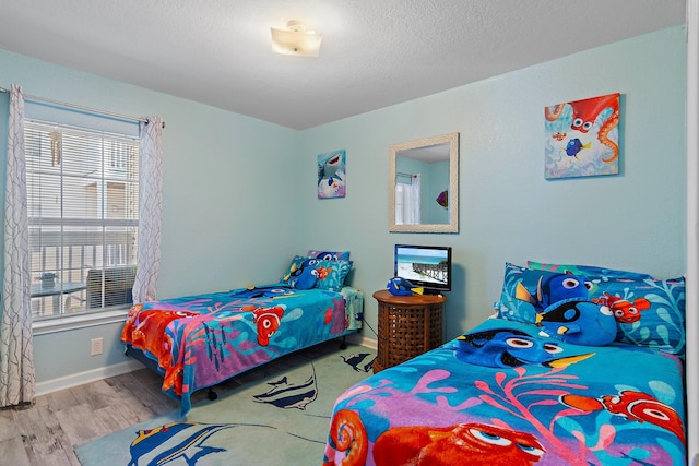 bedroom featuring light hardwood / wood-style flooring and a textured ceiling