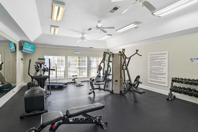 workout area featuring a tray ceiling and crown molding