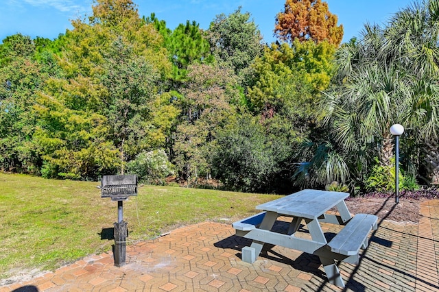 view of property's community featuring a yard and a patio