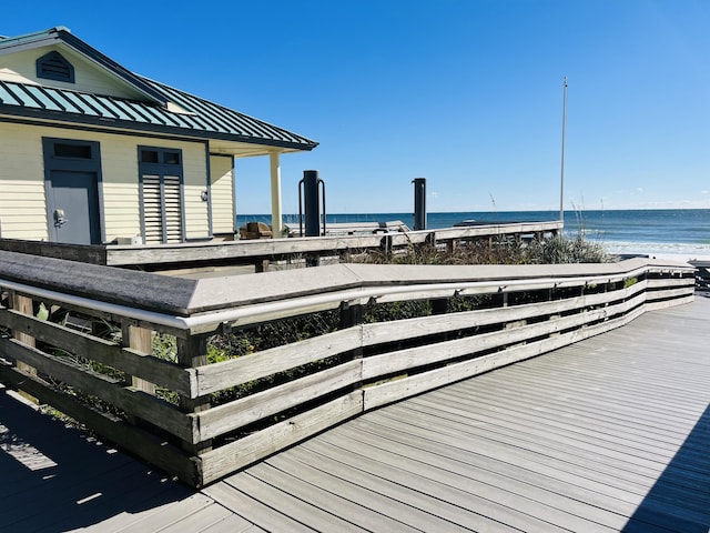 wooden deck featuring a view of the beach and a water view