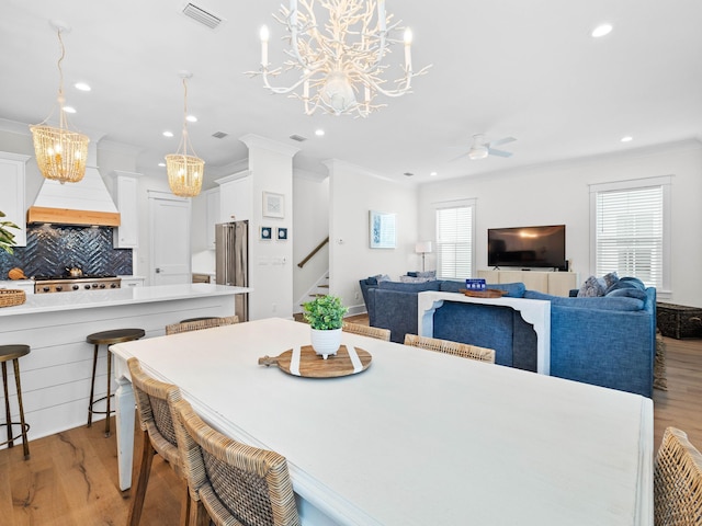 dining room featuring ceiling fan, crown molding, and light wood-type flooring