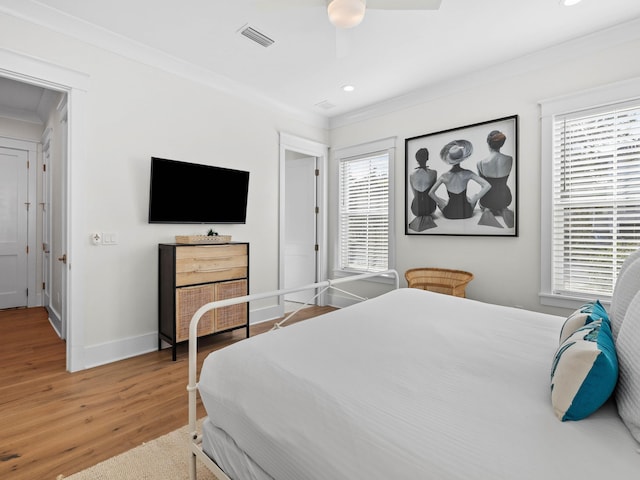 bedroom featuring hardwood / wood-style flooring, ceiling fan, and crown molding