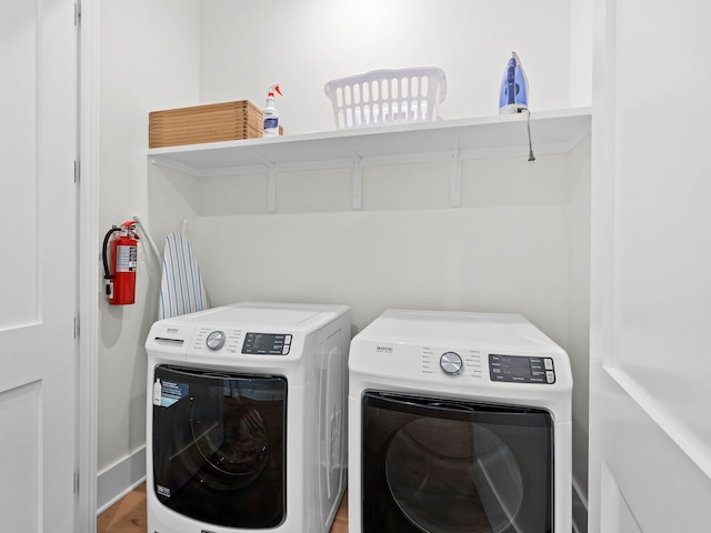 washroom with washer and dryer and wood-type flooring