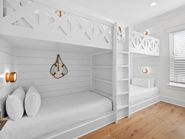 bedroom featuring wood-type flooring and wood walls