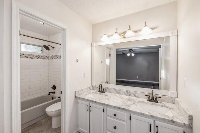 full bathroom featuring ceiling fan, tiled shower / bath combo, a textured ceiling, toilet, and vanity