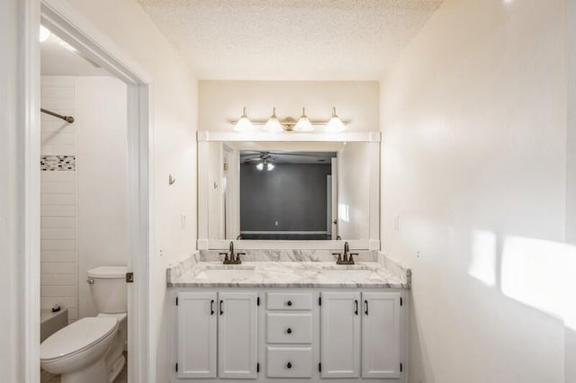 bathroom with vanity, a textured ceiling, toilet, and ceiling fan