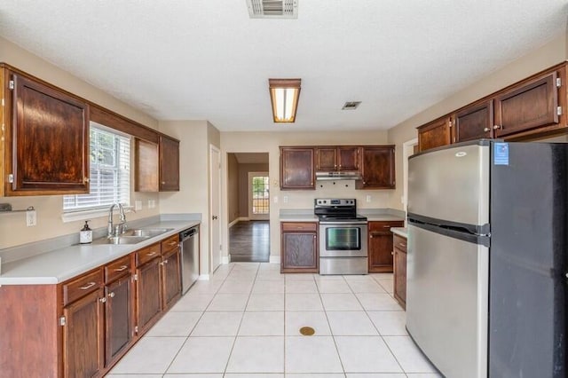 kitchen with light tile patterned flooring, sink, and stainless steel appliances