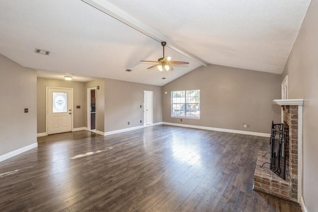 unfurnished living room with vaulted ceiling with beams, dark hardwood / wood-style flooring, a brick fireplace, and ceiling fan