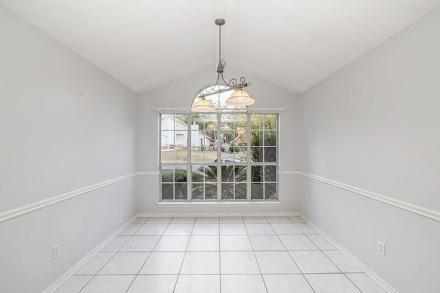 unfurnished dining area with light tile patterned floors and vaulted ceiling