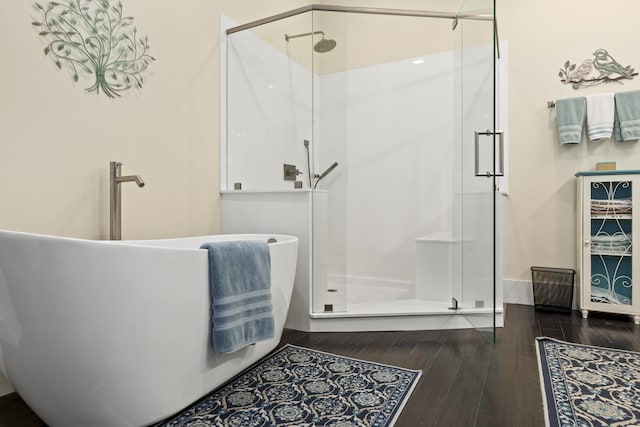 bathroom with hardwood / wood-style flooring and independent shower and bath