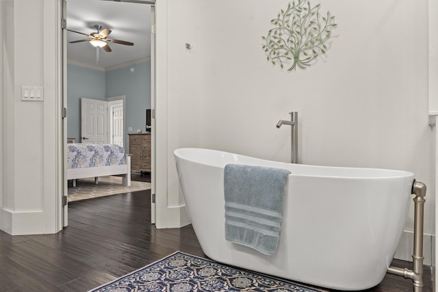 bathroom with crown molding, wood-type flooring, ceiling fan, and a bathtub