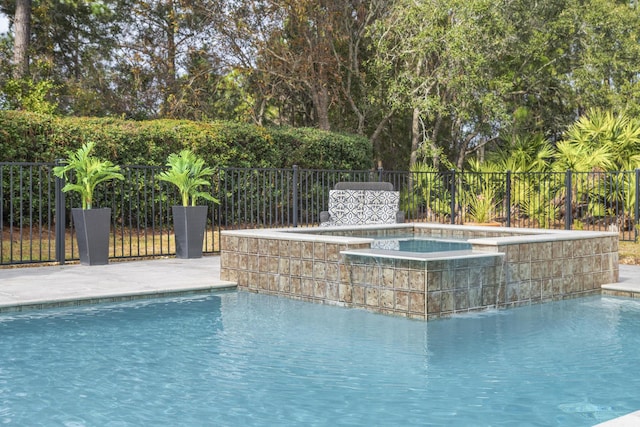 view of pool featuring a patio and an in ground hot tub