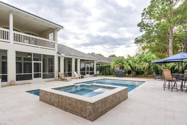 view of swimming pool featuring area for grilling, an in ground hot tub, ceiling fan, a sunroom, and a patio area