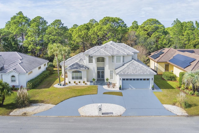 view of front of home with a garage and a front lawn