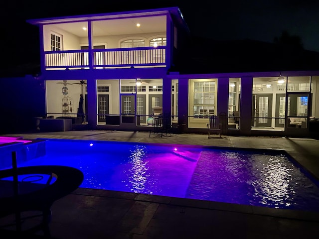 pool at night with a patio area