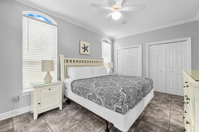 bedroom with multiple closets, dark tile patterned flooring, ceiling fan, and crown molding