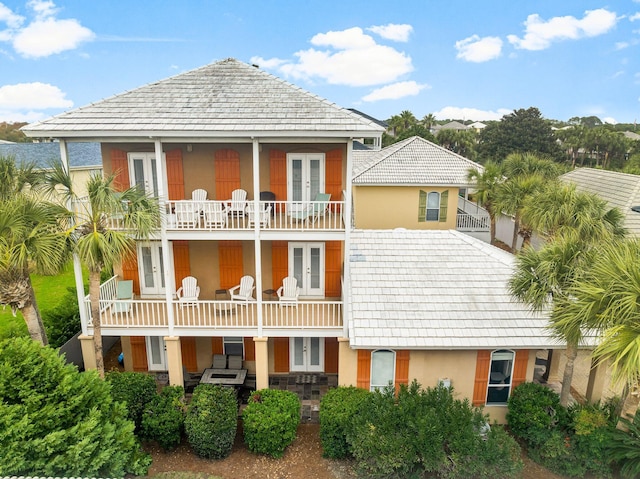 rear view of house featuring a balcony and french doors