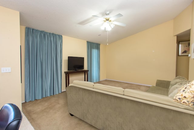 carpeted living room featuring ceiling fan and a textured ceiling