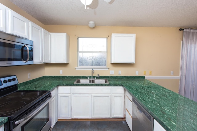 kitchen featuring white cabinets, appliances with stainless steel finishes, a textured ceiling, and sink