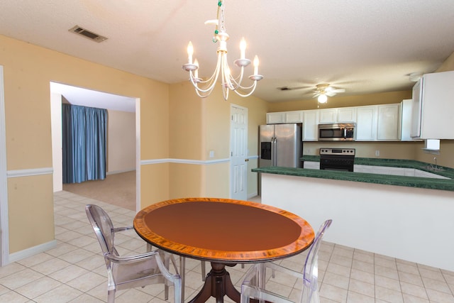 tiled dining space with ceiling fan with notable chandelier and a textured ceiling