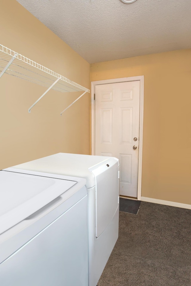 laundry room featuring dark carpet, washing machine and dryer, and a textured ceiling