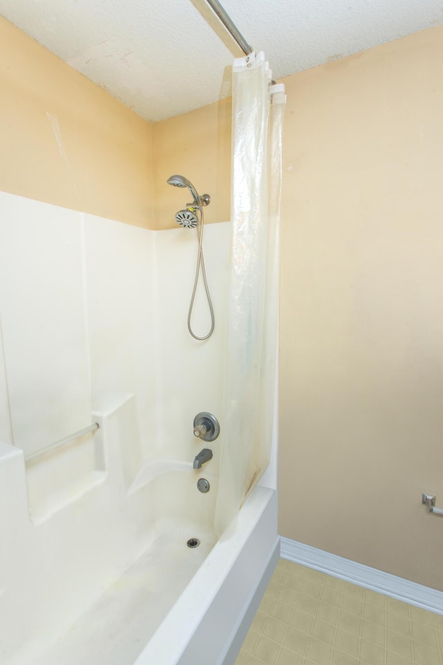 bathroom featuring shower / bath combination with curtain and a textured ceiling