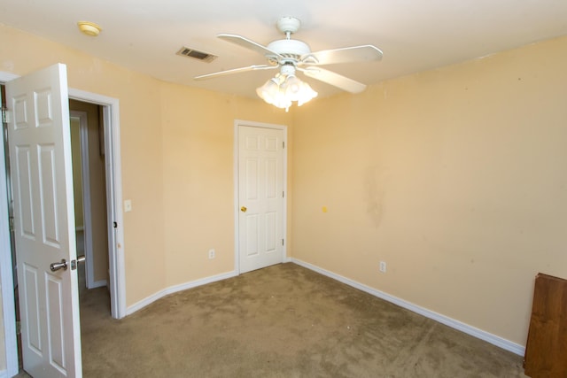 empty room featuring ceiling fan and carpet floors