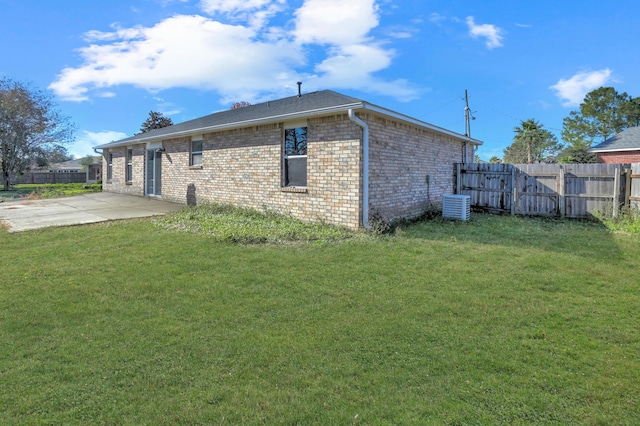 view of side of home featuring a lawn, central AC unit, and a patio area