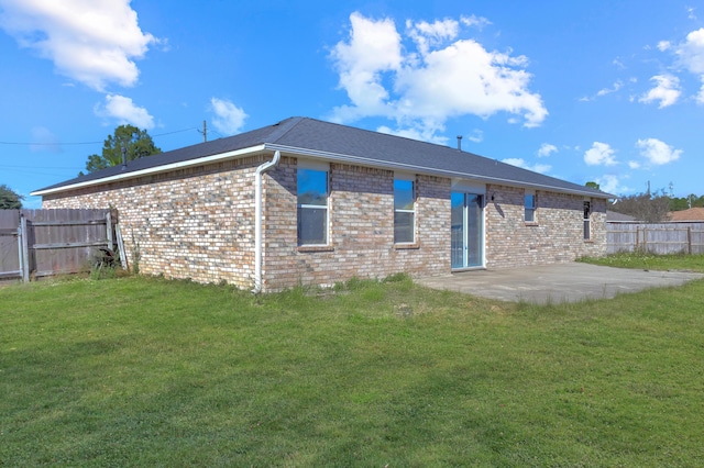 back of house with a patio area and a yard