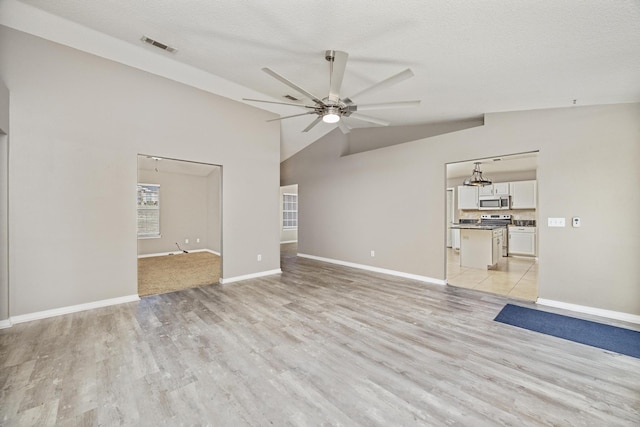 unfurnished living room with a textured ceiling, ceiling fan, light hardwood / wood-style flooring, and lofted ceiling