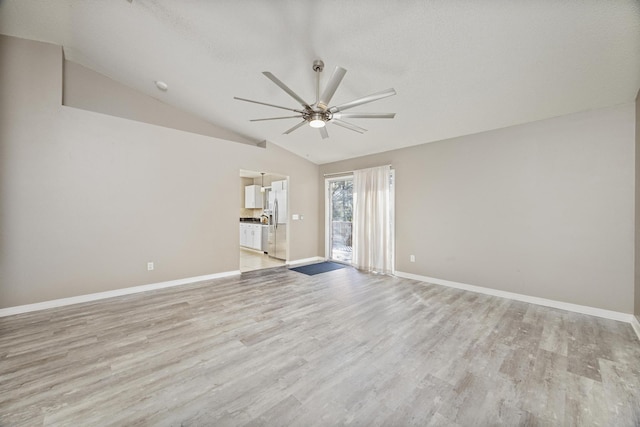 empty room featuring ceiling fan, light hardwood / wood-style flooring, and vaulted ceiling