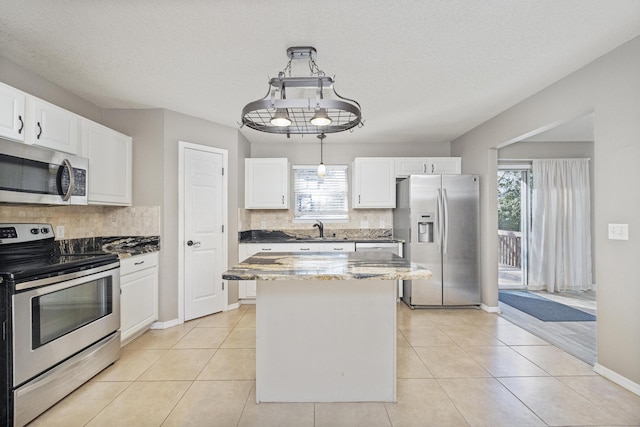 kitchen with white cabinets, a healthy amount of sunlight, and stainless steel appliances