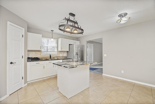 kitchen with white cabinetry, stainless steel fridge with ice dispenser, a center island, and sink