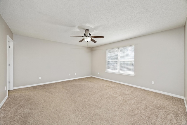 carpeted empty room featuring ceiling fan and a textured ceiling