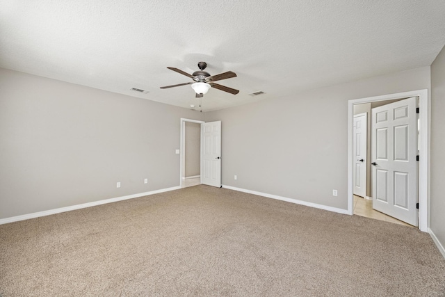 carpeted empty room featuring ceiling fan and a textured ceiling