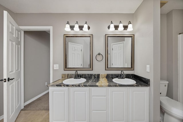 bathroom featuring tile patterned floors, vanity, toilet, and a textured ceiling