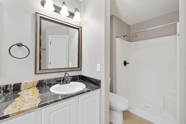 bathroom with a shower, vanity, a textured ceiling, and toilet