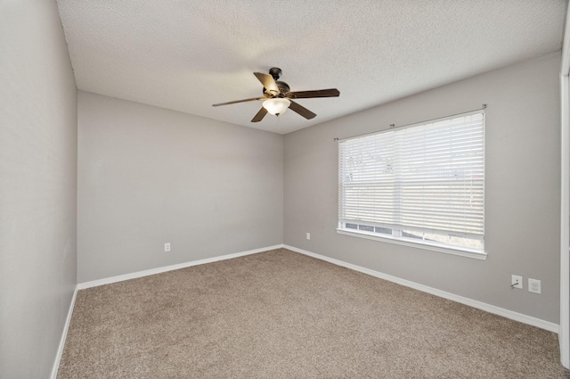 carpeted empty room featuring ceiling fan and a textured ceiling