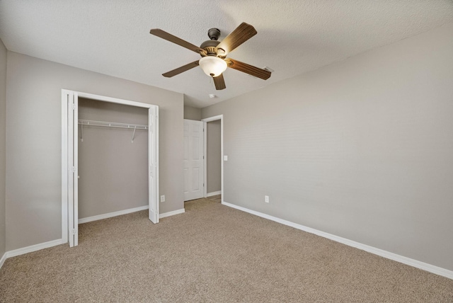 unfurnished bedroom featuring ceiling fan, light carpet, and a textured ceiling