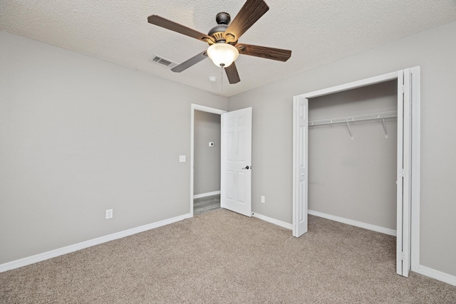 unfurnished bedroom featuring a textured ceiling, light colored carpet, and ceiling fan